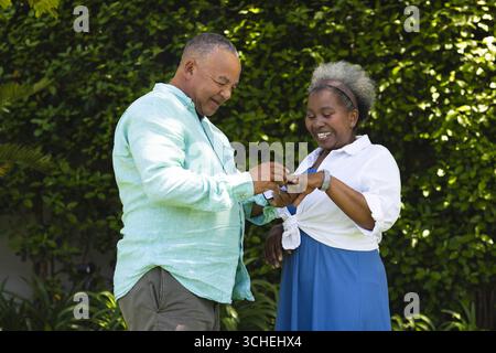 Échange de bagues à l'extérieur, couple senior souriant et partageant un moment spécial ensemble Banque D'Images