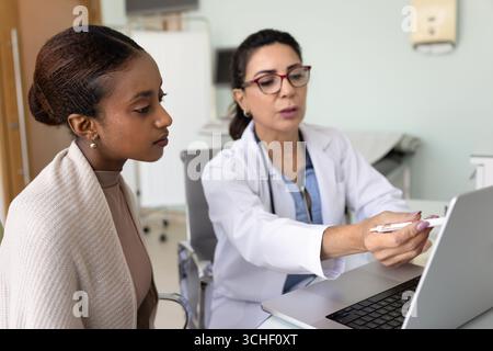 Médecin féminin mature montrer des informations médicales au patient sur ordinateur portable Banque D'Images