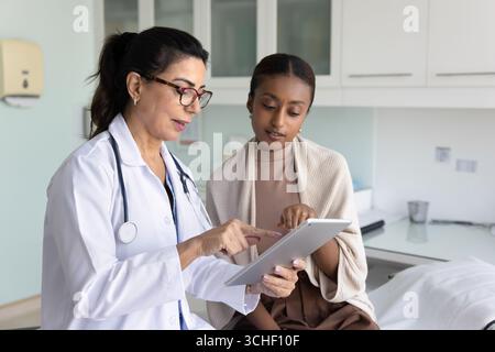 Un spécialiste professionnel de la santé explique le diagnostic à la patiente Banque D'Images
