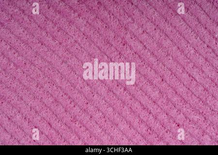 Les éponges de nettoyage domestique close up. Détail d'une éponge, de texture texture éponge close up l'arrière-plan. La texture d'une éponge rouge de cellulose. Treillis métallique sur la mousse rose Banque D'Images