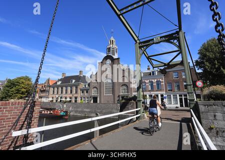 Cycliste traversant le Piet Heynsbrug, vers l'église des Pères pèlerins à Delfshaven, Rotterdam, pays-Bas. Banque D'Images
