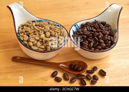 Une comparaison de grains de café vert cru et de grains de café torréfiés foncés dans deux bols en céramique sur fond de bois, montrant le processus de transformation b Banque D'Images