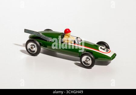 Voiture de course jouet vintage verte avec course pilote sur fond blanc Banque D'Images