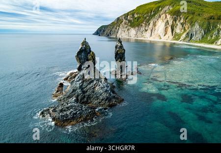 Superbe paysage côtier au lever du soleil avec des formations rocheuses distinctes et des eaux océaniques claires Banque D'Images