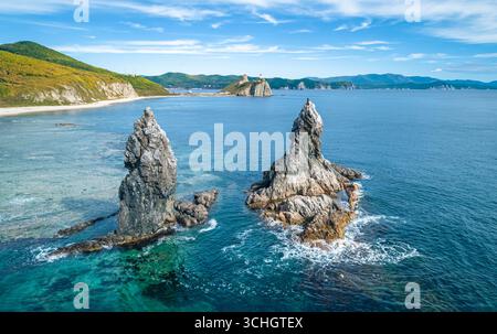 Superbe paysage côtier au lever du soleil avec des formations rocheuses distinctes et des eaux océaniques claires Banque D'Images