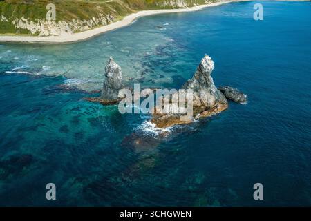 Superbe paysage côtier au lever du soleil avec des formations rocheuses distinctes et des eaux océaniques claires Banque D'Images