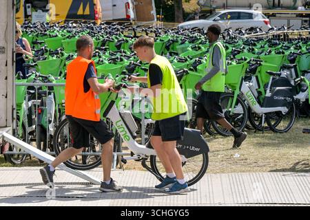 Wimbledon, Londres, Angleterre, Royaume-Uni - 4 juillet 2025 : ouvriers de Lime Bike et Uber chargeant un vélo électrique sur un camion devant le All England Lawn Tennis Banque D'Images