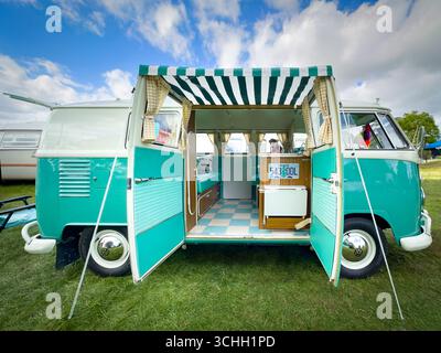 Camping-car volkswagen classique sarcelle et blanc avec portes ouvertes et auvent affichant les détails intérieurs lors d'une exposition en plein air dans l'oregon Banque D'Images