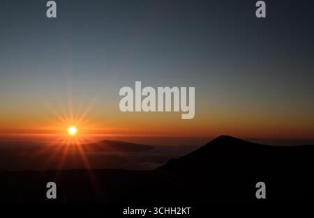 Coucher de soleil au-dessus des nuages depuis le sommet du Mauna Kea, HawaiiBig Island Hawaii. Banque D'Images