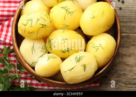 Savoureuses pommes de terre jeunes bouillies à l'aneth servies sur une table en bois, vue de dessus Banque D'Images