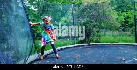 Fille s'amusant sur un trampoline Banque D'Images