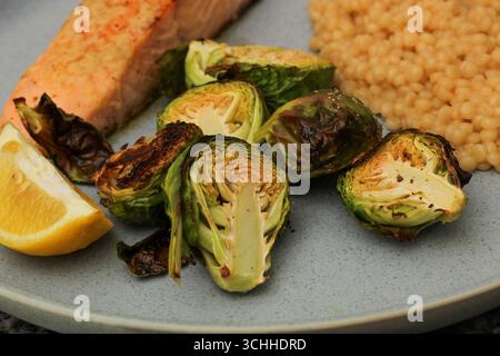 Gros plan de repas préparés avec choux de Bruxelles, couscous et saumon Banque D'Images