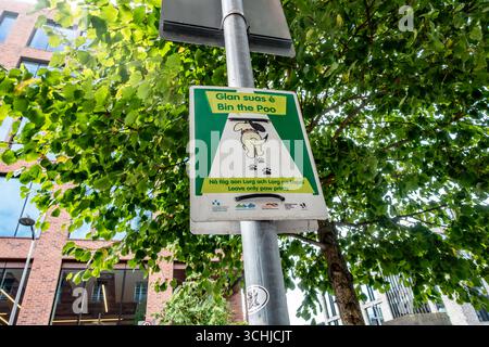 Panneau de rue bilingue irlandais à Dublin indiquant « Bin the Poo – Leave Only Paw Prints », encourageant les propriétaires de chiens à nettoyer après les animaux de compagnie dans les espaces publics. Banque D'Images