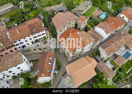 Vue aérienne par drone de maisons en pierre avec des toits de tuiles rouges et des rues pavées étroites dans la ville médiévale perchée de Motovun, Istrie, Croatie. Banque D'Images