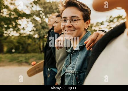 Portrait de jeune homme hipster souriant marchant avec des amis Banque D'Images