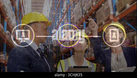Les gestionnaires portant un gilet de sécurité et un casque de sécurité vérifiant les boîtes dans l'allée de l'entrepôt, avec des icônes numériques Banque D'Images