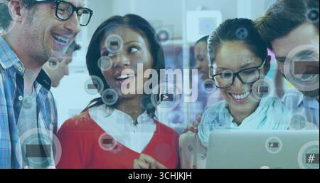 Quatre collègues collaborent et réfléchissent autour d'un ordinateur portable au bureau, avec des icônes numériques flottantes Banque D'Images