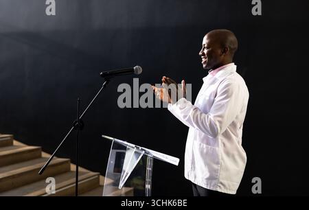 homme applaudissant tout en parlant au podium pendant la présentation d'affaires, à la salle de conférence, espace de copie Banque D'Images