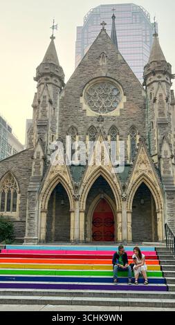 Montréal QC, Canada - 03 août 2025 : L'église réunie James présente des marches colorées où deux femmes s'assoient, mêlant architecture historique et moderne Banque D'Images