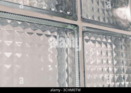 Vue rapprochée de blocs de verre transparents aux textures variées laissant passer la lumière. Le design crée un effet visuel intéressant dans un Banque D'Images