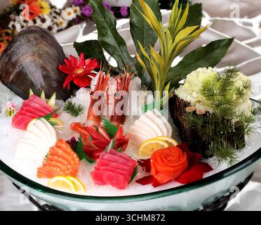 Assiette sashimi assortie avec thon, saumon et crevettes sur glace Banque D'Images