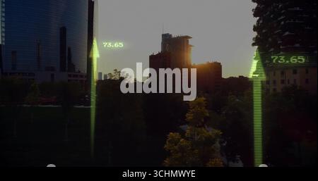 Vue de la ligne d'horizon s'élevant au-dessus d'un parc bordé d'arbres au coucher du soleil, avec gratte-ciel en verre et 73 Banque D'Images