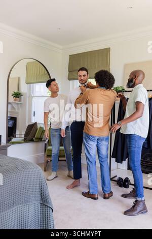 Marié se préparer avec des amis ajustant le noeud papillon dans une chambre élégante Banque D'Images