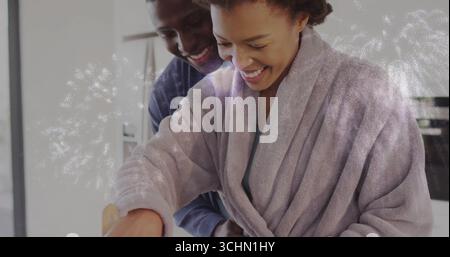 Couple cuisinier portant peignoir et chemise à manches longues remuant bol dans la cuisine à la maison, cuillère en bois Banque D'Images