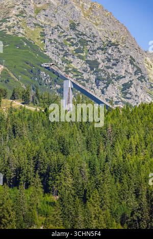 Vieille tour de saut à ski au-dessus du lac Strbske Pleso dans les Hautes Tatras, entourée de montagnes, Slovaquie. Parc national des Hautes Tatras Banque D'Images