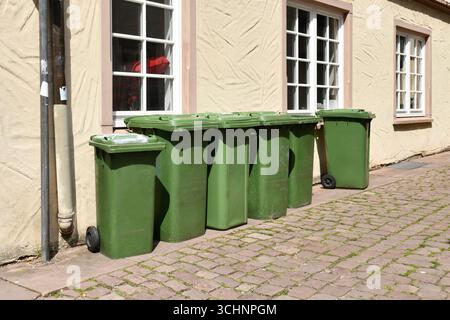 Poubelles à roulettes vertes placées sur une rue résidentielle en Allemagne pour la collecte des déchets Banque D'Images