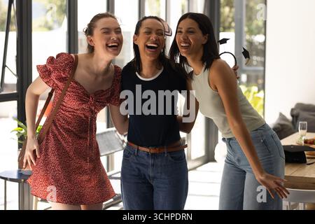 Riant ensemble, trois jeunes femmes profitent d'une journée ensoleillée à l'intérieur Banque D'Images