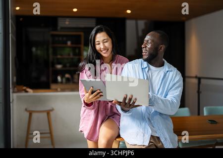 Un couple heureux et multinational qui sont des nomades numériques et travaillent dans un pays différent chaque mois Banque D'Images