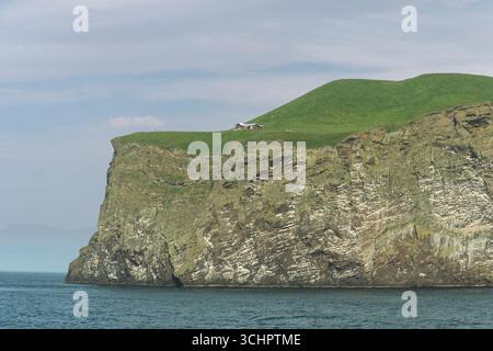 Vue des falaises près du port sur l'île volcanique de Heimaey, Islande, 14 juillet 2025 Banque D'Images