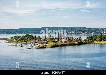 Nakholmen Island Summer Cottages Oslo Norvège // OSLO, Norvège — la petite île de Nakholmen, située entre Lindøya et la péninsule de Bygdøy, abrite près de 200 chalets d'été privés. L'île est accessible via la ligne de ferry B1/B2 depuis l'embarcadère 4 de l'hôtel de ville, avec une promenade en bateau d'environ 15 minutes. À leur arrivée, les visiteurs débarquent à l'embarcadère du côté nord-est de l'île. Nakholmen est principalement connu comme une île cottage, avec les parties méridionales désignées comme une réserve naturelle. Banque D'Images
