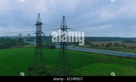 Lignes électriques à haute tension au-dessus de l'autoroute - vue aérienne du drone Banque D'Images