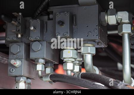 Système de tuyaux hydrauliques haute pression connecté avec des tuyaux en acier et connecté au système, gros plan. Hydraulique d'une grue de camion de grande taille. Banque D'Images