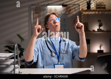 Infirmière fatiguée et stressée travaillant pendant des heures à l'expertise médicale dans le bureau de l'hôpital, dactylographiant le rapport du patient sur ordinateur. Assistant examinant Medi Banque D'Images