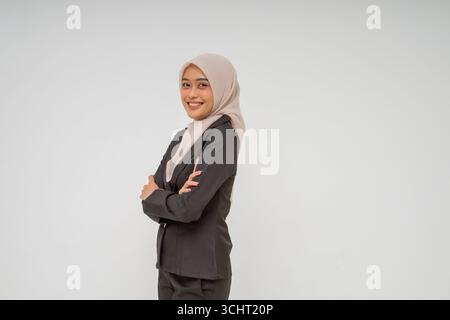 Une jeune femme d'affaires confiante vêtue d'une tenue professionnelle, portant fièrement un hijab Banque D'Images