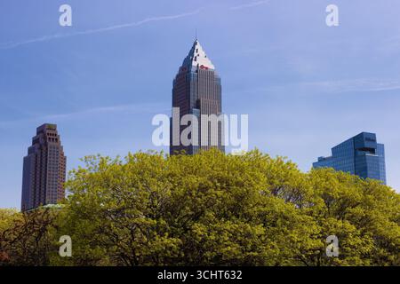 Cleveland, Ohio, États-Unis - 18 mai 2023 : gratte-ciel s'élèvent au-dessus des cimes des arbres vus de l'extérieur du Rock and Roll Hall of Fame Building. Banque D'Images