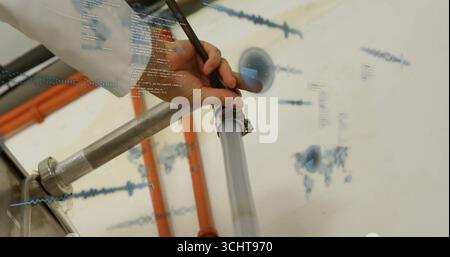 Technicien revêtu d'une blouse de laboratoire fixant le collier sur le tuyau en laboratoire, avec tuyaux et revêtements numériques Banque D'Images