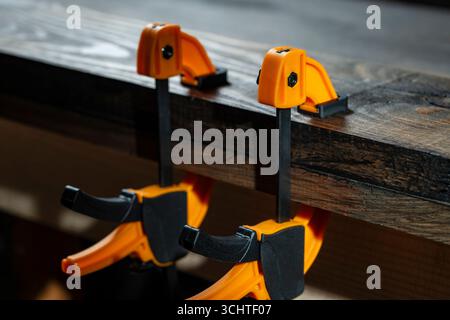 Charpentier deux pinces sont fixées aux planches, gros plan. Outils de menuiserie dans l'atelier de la maison Banque D'Images
