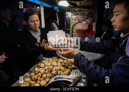 TAIPEI, TAIWAN - 18 décembre : les habitants achètent de la nourriture à des vendeurs ambulants. Des foules de gens ont emballé le marché nocturne de Shilin le 18 décembre à Taipei, Taiwan. Banque D'Images