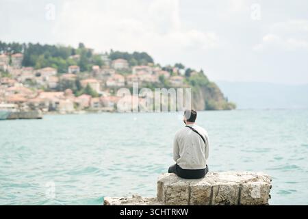 Un jeune homme admire le lac Ohrid. Vue de l'arrière Banque D'Images