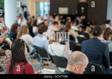 Les personnes participant à un séminaire prêtent attention à la présentation des conférenciers dans une salle. Banque D'Images