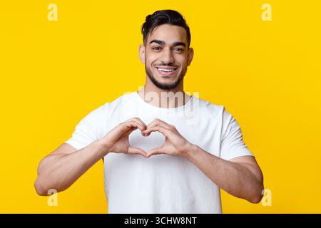 Beau mec arabe montrant du coeur avec ses mains Banque D'Images