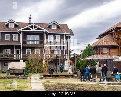 Un groupe d'amis se détendant dans une arrière-cour avec des balançoires et un pavillon ombragé, profitant de la compagnie de l'autre sur une journée nuageuse avec un accent sélectif sur le Banque D'Images