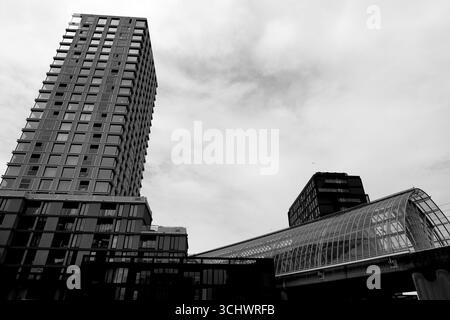Grande tour résidentielle et verrière de transit en verre voûtée à Sloterdijk, Amsterdam, pays-Bas, vue d'en bas sous un ciel couvert de jour au-dessus. Banque D'Images