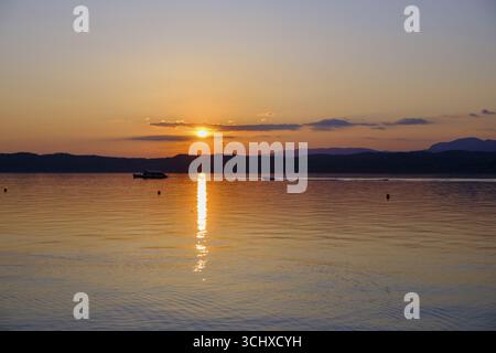 Coucher de soleil à Lido delle Grotte, Jamaica Beach, Sirmione sur le lac de Garde, Vénétie, Vénétie, Italie Banque D'Images