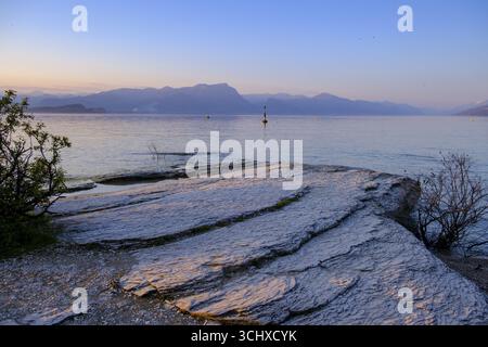 Coucher de soleil à Lido delle Grotte, Jamaica Beach, Sirmione sur le lac de Garde, Vénétie, Vénétie, Italie Banque D'Images