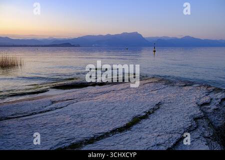 Coucher de soleil à Lido delle Grotte, Jamaica Beach, Sirmione sur le lac de Garde, Vénétie, Vénétie, Italie Banque D'Images